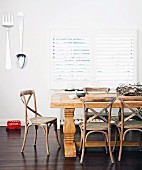 Dining area with solid wood dining table & oversized cutlery decorating wall
