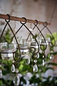 Decorative glass tealight holders hanging from metal rod
