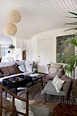 Metallstühle mit Sitzpolstern und Retrotisch in skandinavisch inspiriertem Wohnraum mit gewölbter Holzdecke