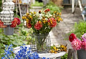 Sommerstrauss mit Dahlien, Alstroemeria und Rudbeckia auf Gartentisch