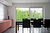 Designer dining room with dining area in front of terrace windows with view of garden