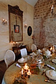 Old, exposed brick masonry in old building as backdrop for long, festively set, Rococo-style table