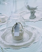 White, vintage-style place setting with decoration and name tag on plate