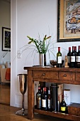 A rustic dresser with an assortment of bottles of wine and spirits