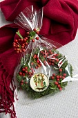 Wreath of holly berries with Father Christmas pendant wrapped as present