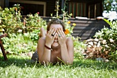 Woman lying on lawn covering her eyes
