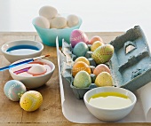 Decorated eggs next to bowls of dye