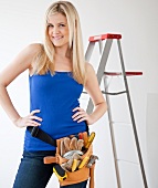Portrait of young woman wearing tool belt