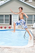 Boy jumping into swimming pool
