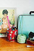 Picture of woman, bag, metal can of pens & knitting yarn on cabinet
