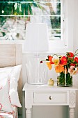 Summer bouquet in glass vase on white, vintage bedside table