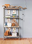 Simple, industrial-style shelving unit decorated with natural materials; pendant lamp cables wrapped casually around branch