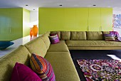 Gelbe Fronten und violette Akzente in minimalistischem Wohnzimmer mit riesiger Eckcouch