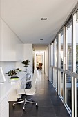 Quiet workspace in bright corridor with floor-to-ceiling windows