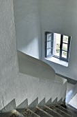 Open window in white stairwell with grey steps