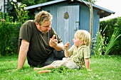 Germany, Bavaria, Father and son eating carrots