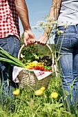 Germany, Cologne, Young couple with picnic basket in meadow
