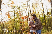 Couple hugging one another in autumnal woodland