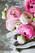 Pink and white ranunculus in basket of white twigs