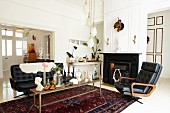 Simple bench on ethnic rug and vintage, leather sofa set in front of wide doorway in grand living room with open fireplace