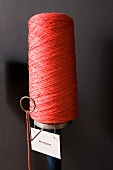 Bobbin of red yarn with label
