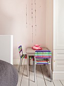 Sitting area with colorful wicker chairs and pink coffee service in a child's room