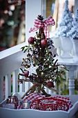 Twig Christmas tree with decorations on small terrace table