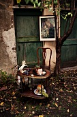Antique table and chair in front of rustic doors; sliced joint of roast pork on table