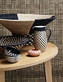 Simple wooden table with assorted, ethnic style, checkerboard wicker weave containers