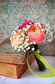 Spring posy with ranunculus and gypsophila next to old books