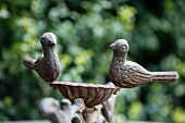 Bird bath with two metal bird figurines