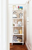 Kitchen utensils on white-painted wooden shelving in corner of room with traditional elements