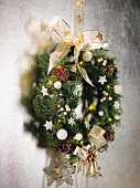 Weihnachtlich dekorierter Kranz mit Schleife an Wand aufgehängt