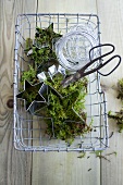 Wire basket with moss, aluminum wire, star-shaped cookie cutters and scissors