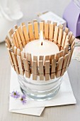 Glass tealight holder decorated with clothed pegs