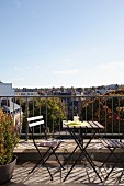 Klapptischgarnitur auf sonnigem Balkon mit Blick über die Dächer von Brüssel