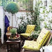 Small, planted courtyard with wooden chairs