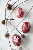 Three Easter eggs colored with natural dyes (red beet)