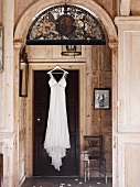 Still life with nostalgic wedding dress on a wooden door in a paneled room