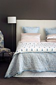 Double bed with pastel pillows and silky bedspread
