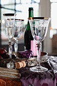 Champagne glass, wine glasses and wine bottle on a table set for Christmas