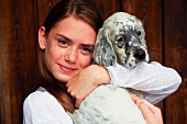 Teenage girl holding dog