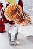 Wheels of folded newspaper decorating a drinks glass