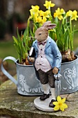 Rabbit figurine in front of potted narcissus