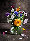 Posy of wild flowers in drinking glass
