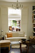 Vintage stool and pale sofa in front of open double doors with view into study