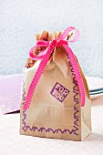 Paper gift bag with ribbon and pattern made using hand-carved rubber stamps