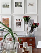 Various glass vessels, protea flowers and framed pictures