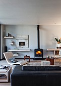 Contemporary interior with leather sofa, chair & fire in wood-burning stove