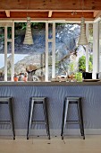 Metal, retro-style bar stools at counter and view of boulder through window